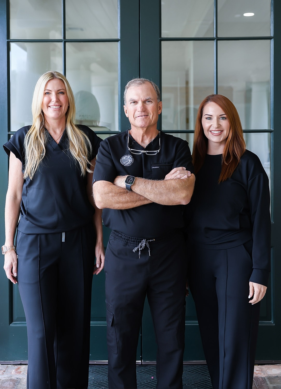Healthcare professionals posing together in black uniforms.