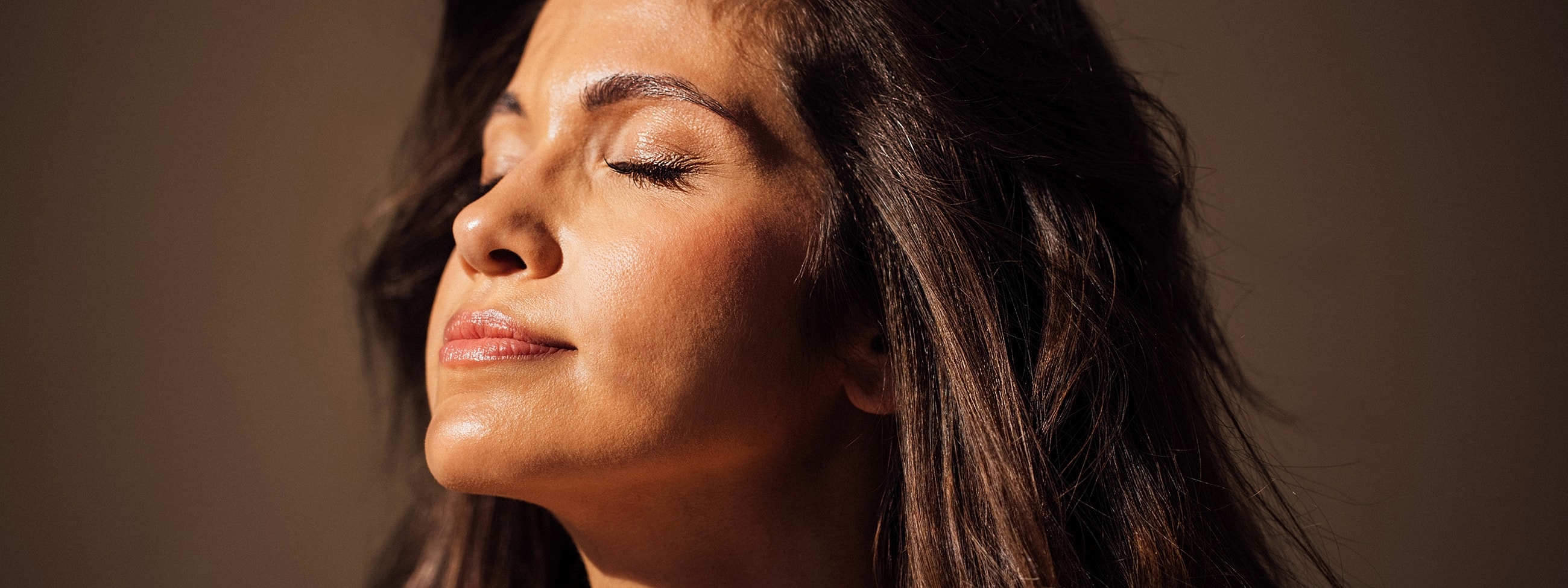 Woman enjoying sunlight with eyes closed.